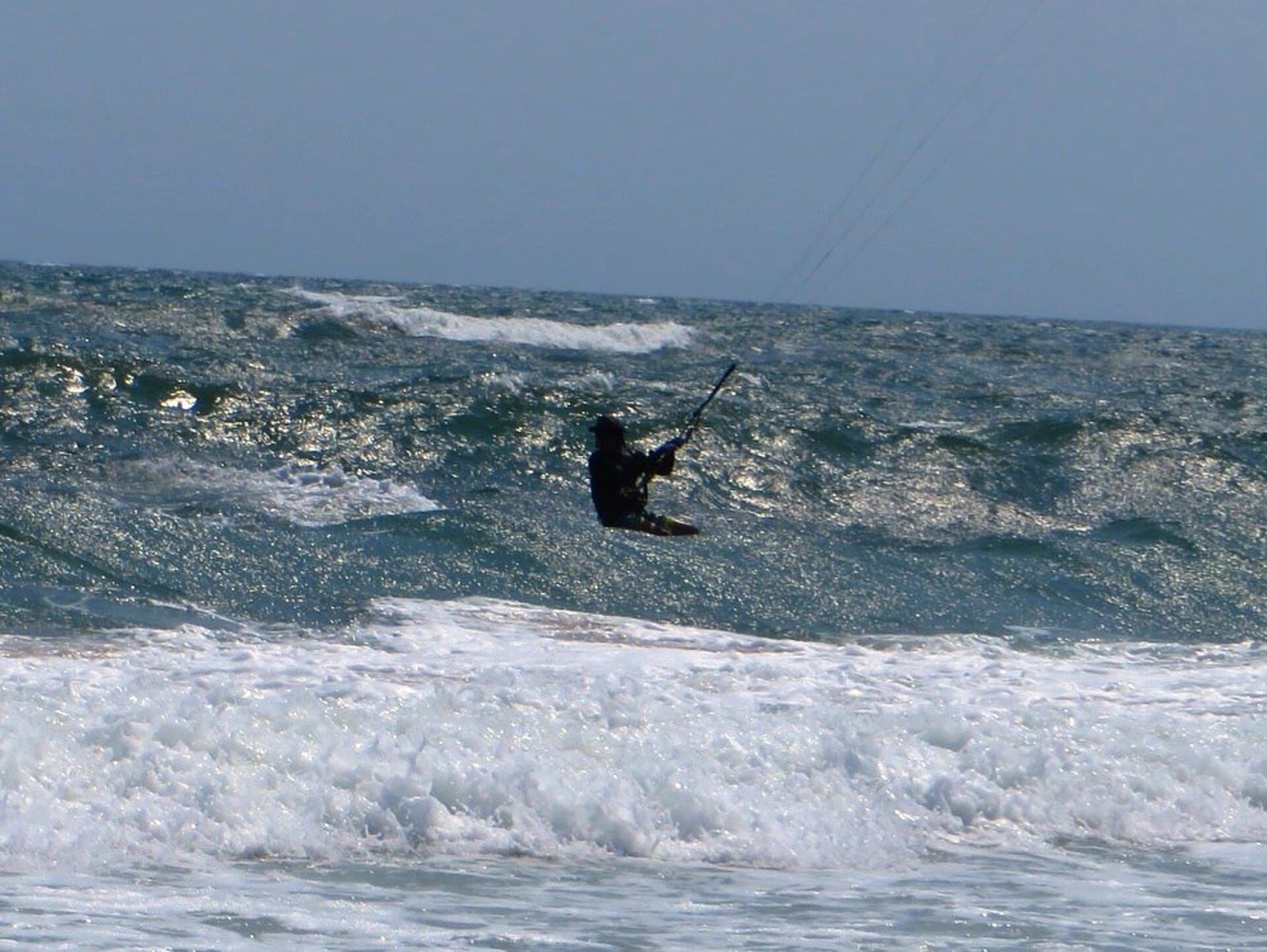 Kitesurfer on a downwind run along the coast (Cape Hatteras, USA).